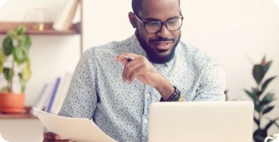 A photo of a person checking documents on their laptop