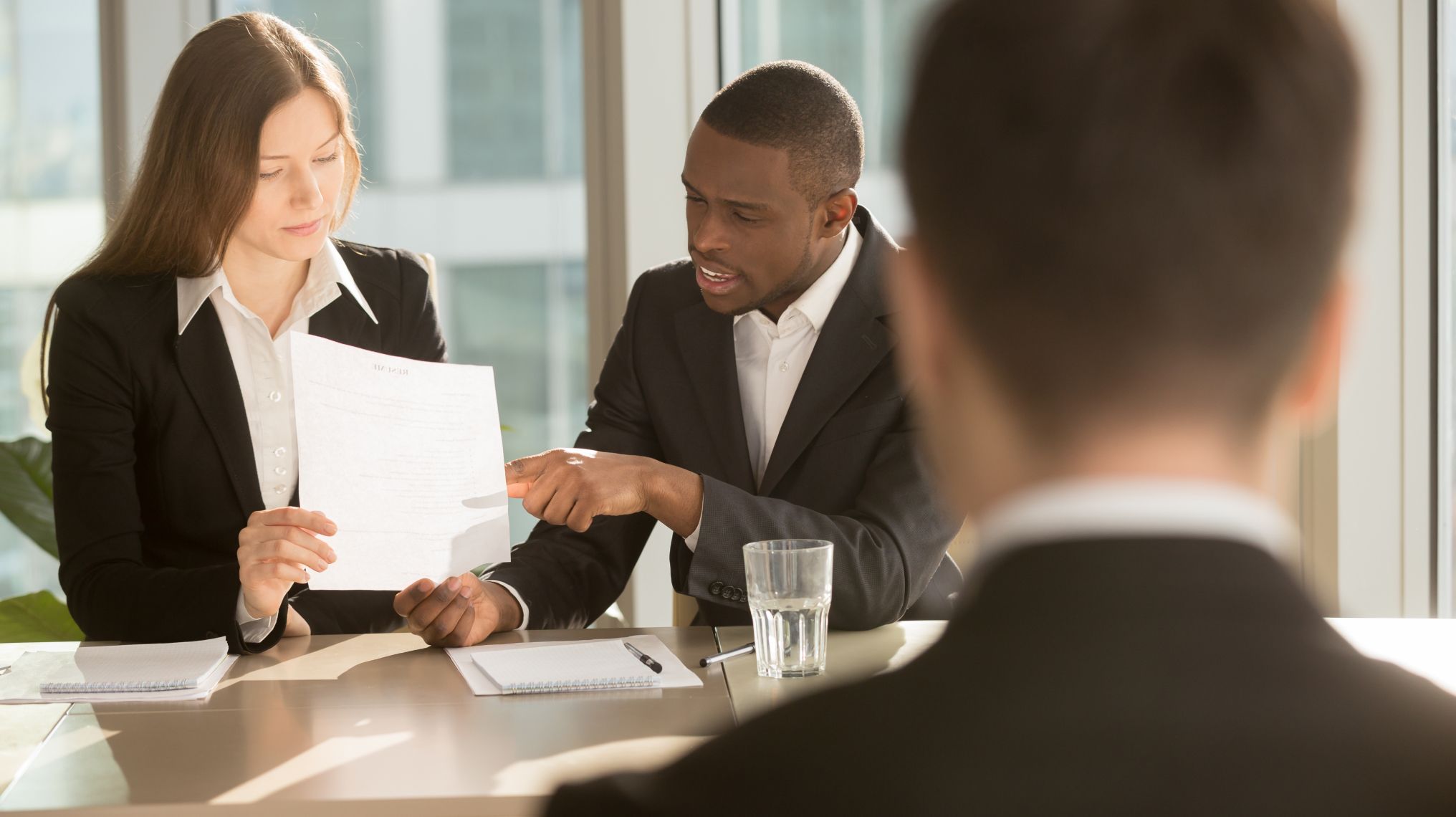 Colleagues at a work meeting reading and discussing written legal changes