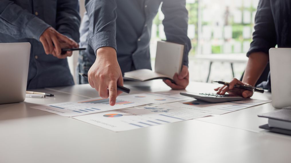 Colleagues reading and discussing papers on a desk