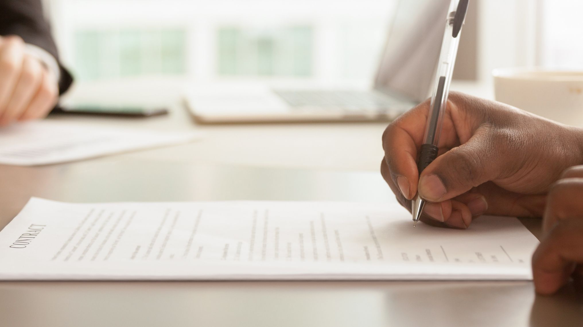 Colleagues reading and signing a legal contract