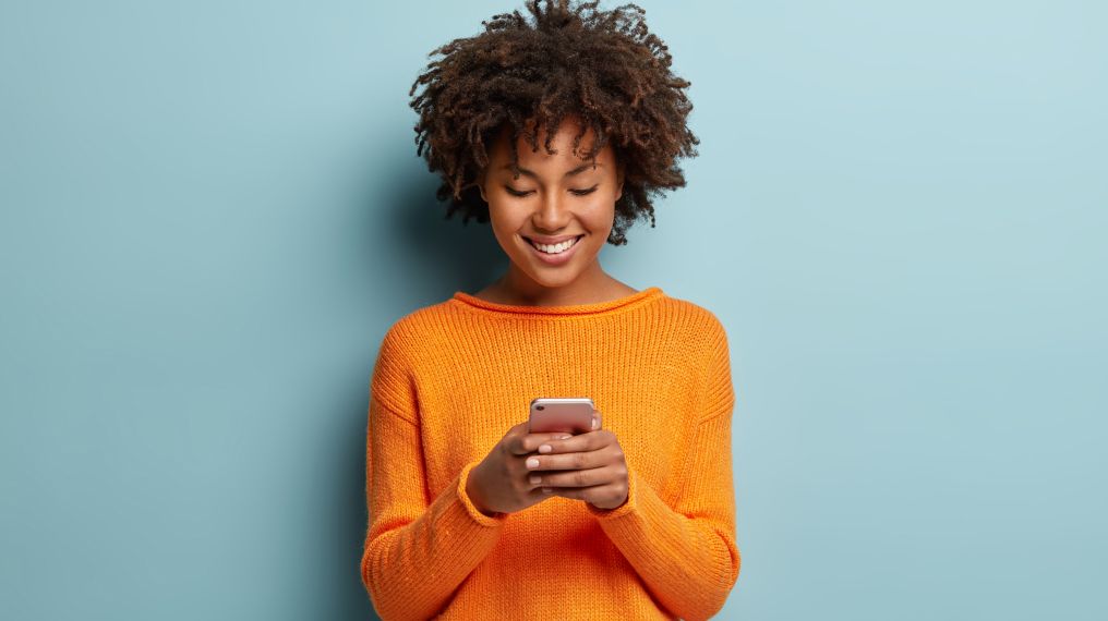 Employee smiling and happy at work using their smartphone