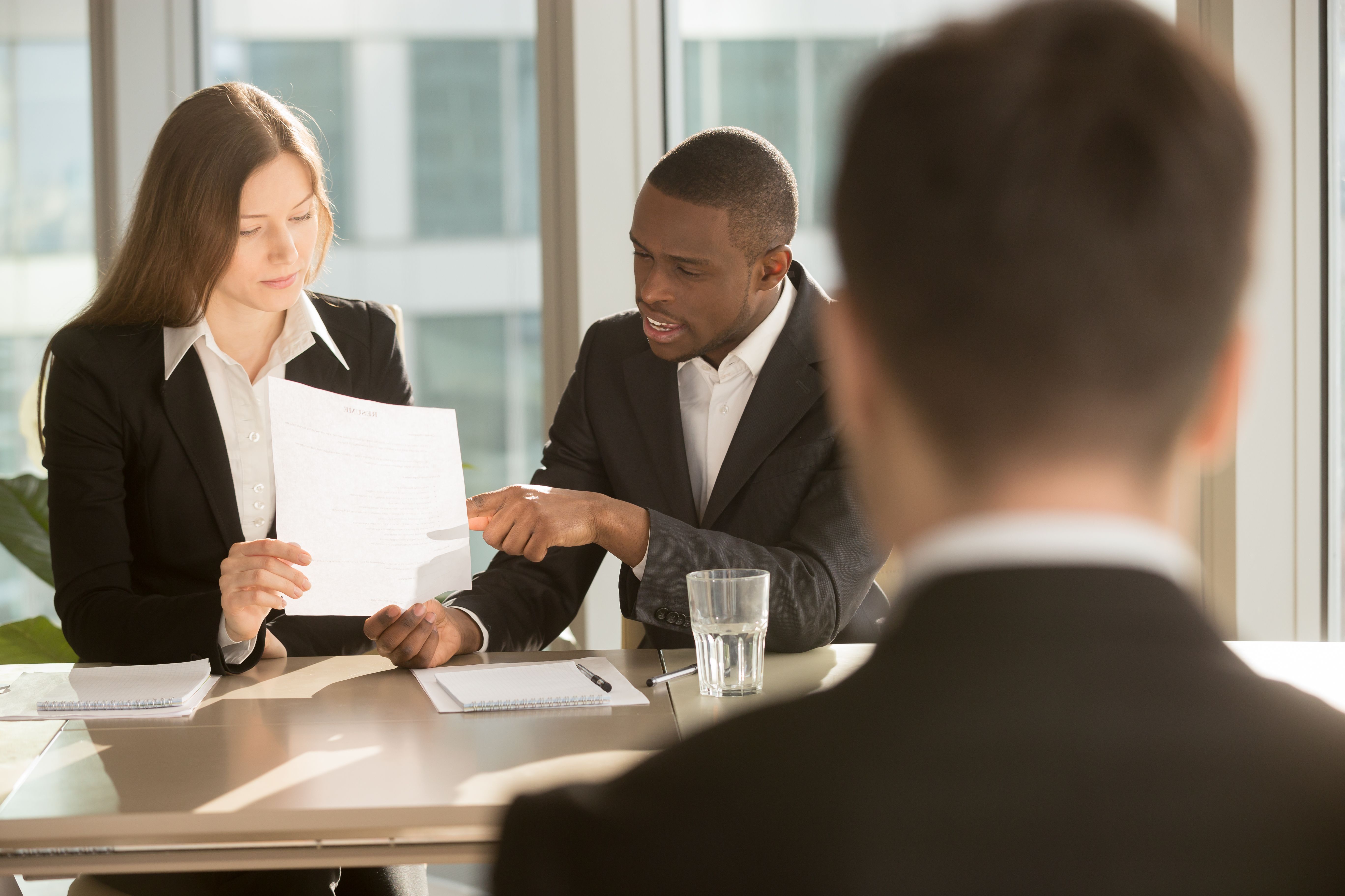 Colleagues at a work meeting reading and discussing written legal changes 